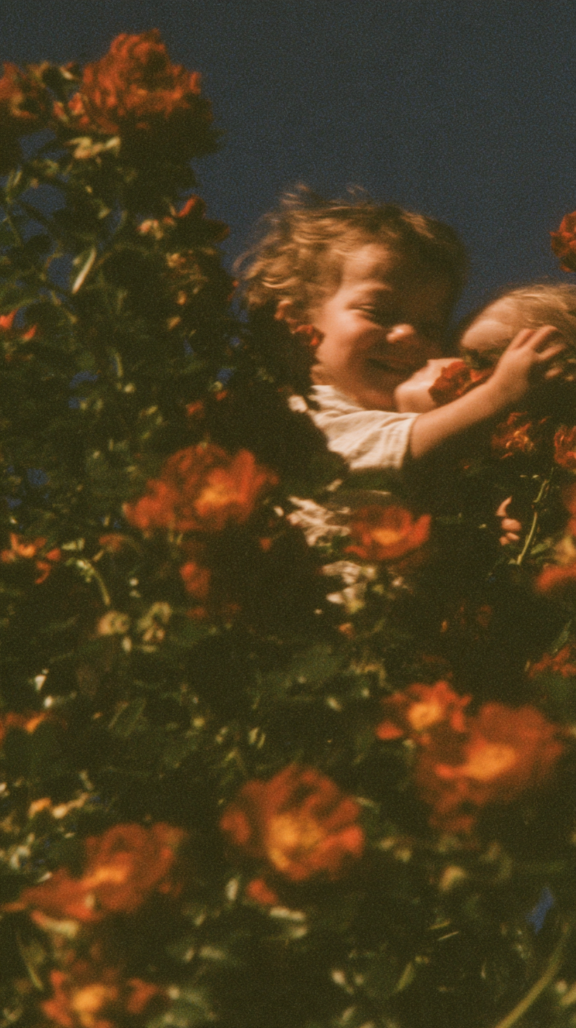 A child smiling between red flowers