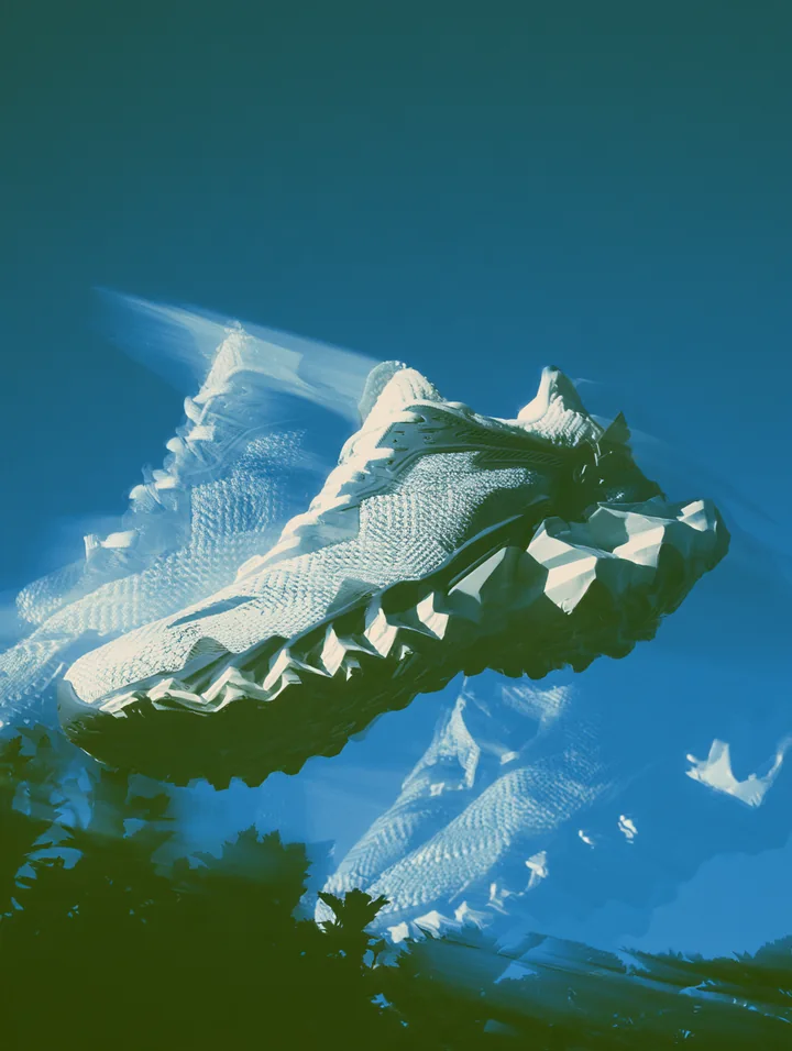 A white sculptural running shoe suspended against vivid blue with motion-like reflections